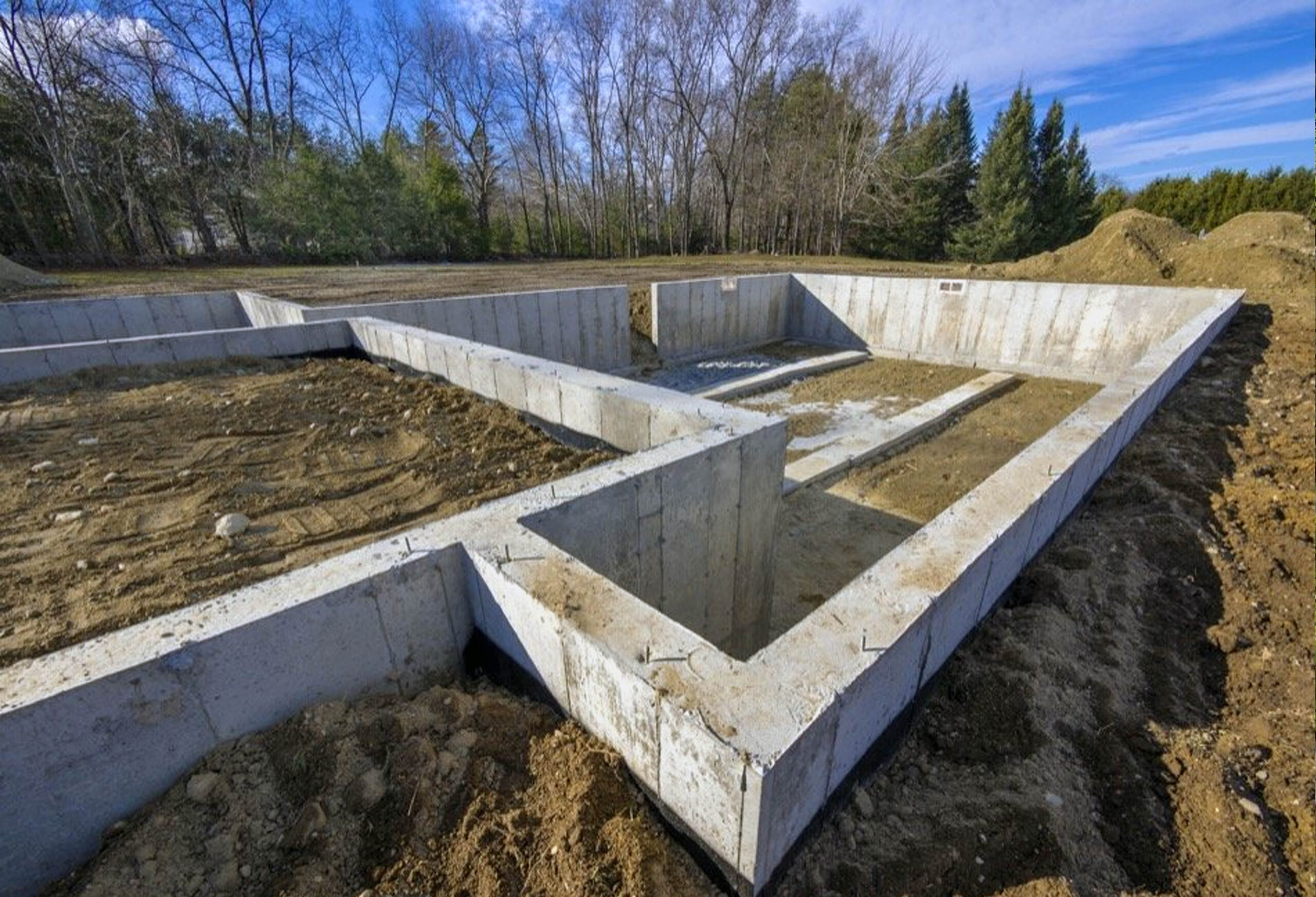 A residential concrete foundation under construction, with reinforced steel rebar and freshly poured concrete for a new home build in Spokane.