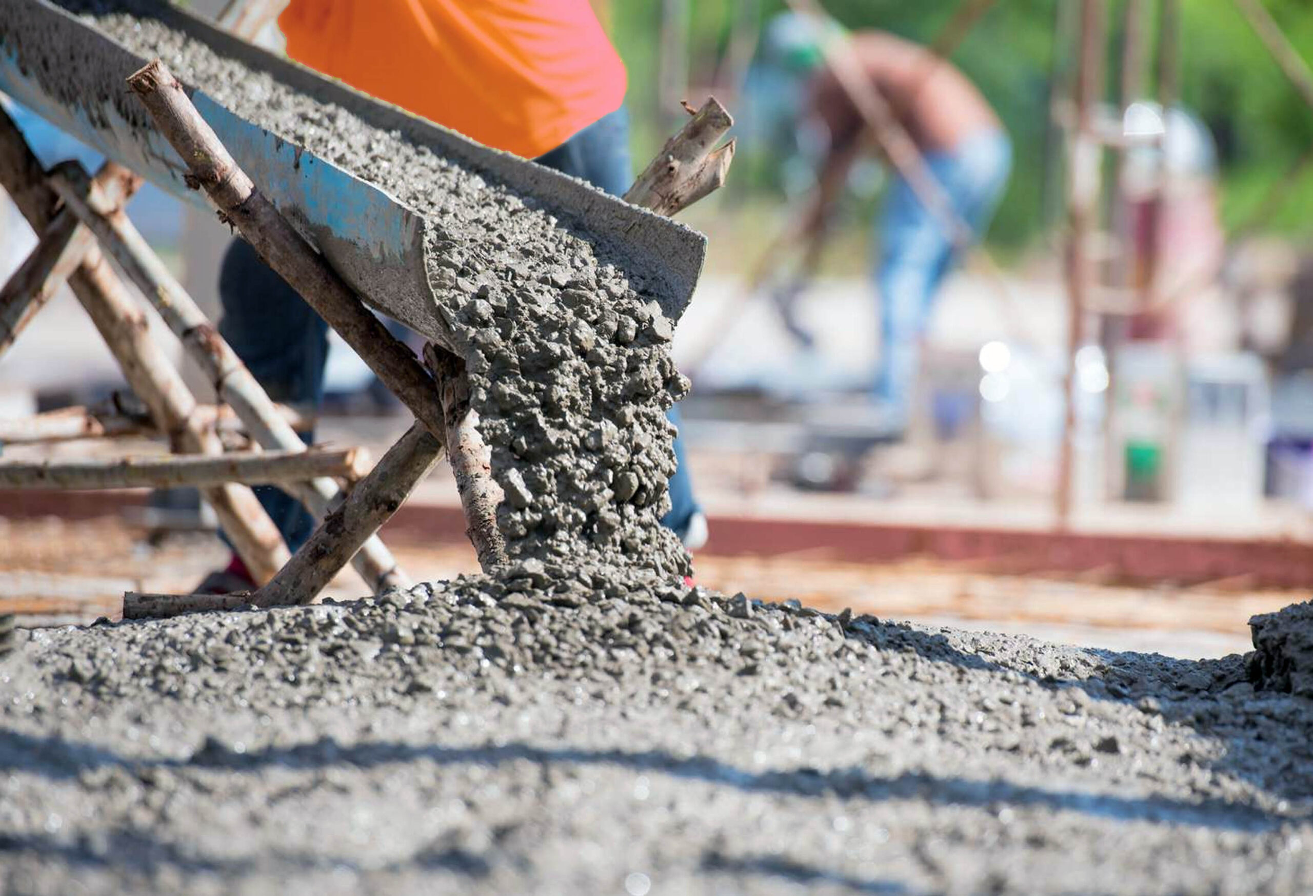 Fresh concrete pouring from a mixer truck onto a construction site, showcasing expert concrete mixing and pouring services in Spokane.